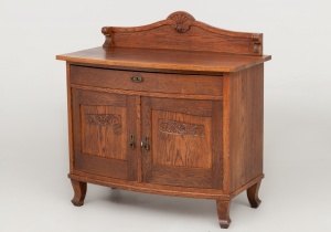 картинка Старинный дубовый комод с распашными дверцами, декорированными резьбой салоне старинных вещей "Шебби" являющийся официальным дистрибьютором в России и Беларуси