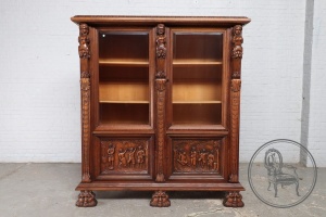 картинка Антикварная витрина, декорированная барельефами и резными филенками со сценами веселья салоне старинных вещей "Шебби" являющийся официальным дистрибьютором в России и Беларуси